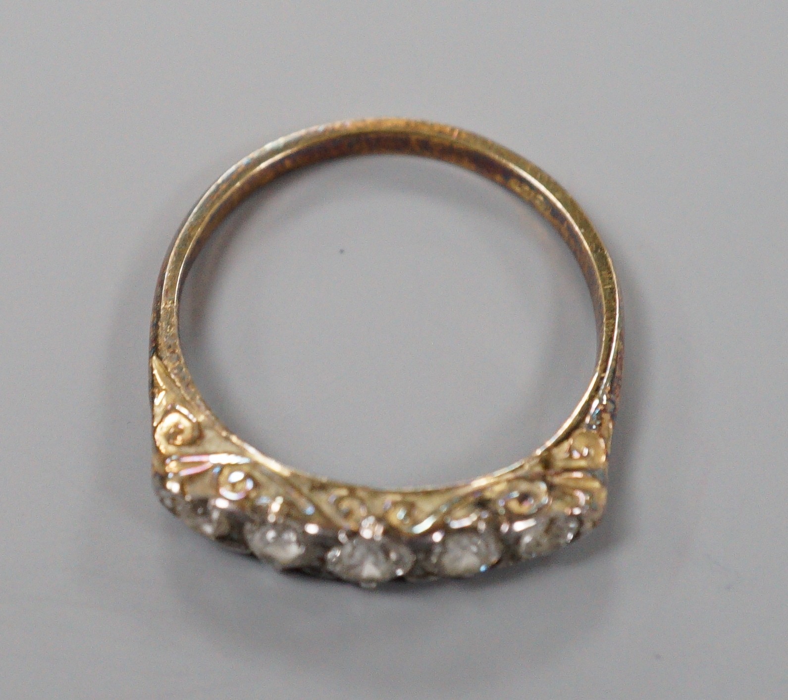 An early 20th century 18ct and graduated five stone diamond set half hoop ring, size P/Q, gross weight 2.7 grams.